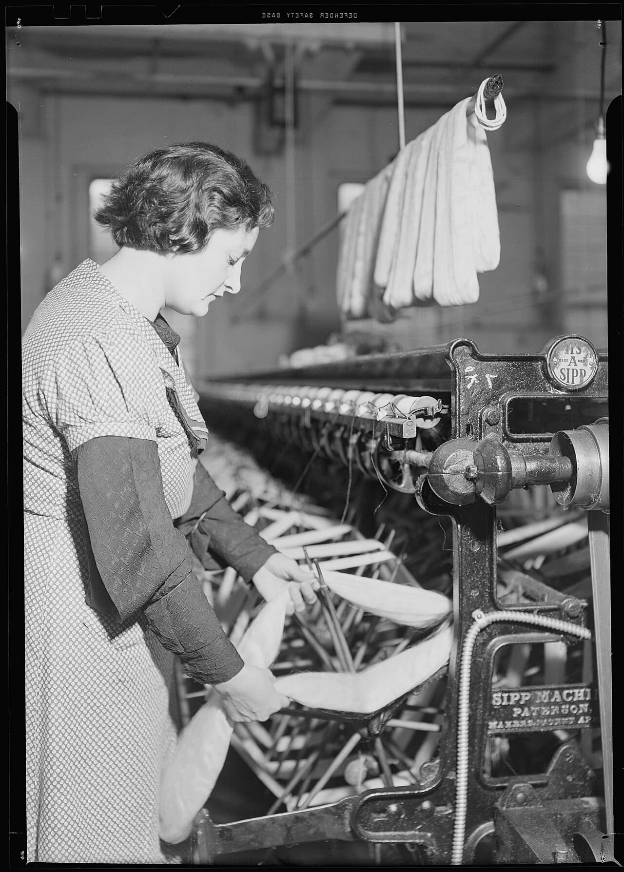 Textile mill workers in Paterson, New Jersey placing yarn skeins onto swifts after drying, circa 1937, showing industrial-scale skein-to-ball winding