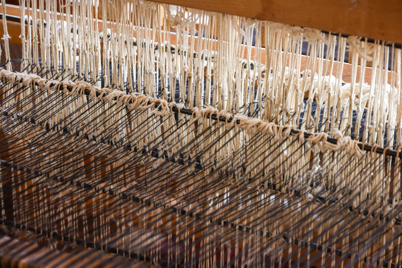 Three rigid heddle looms of different sizes on a wooden table, showing the range from compact to wide