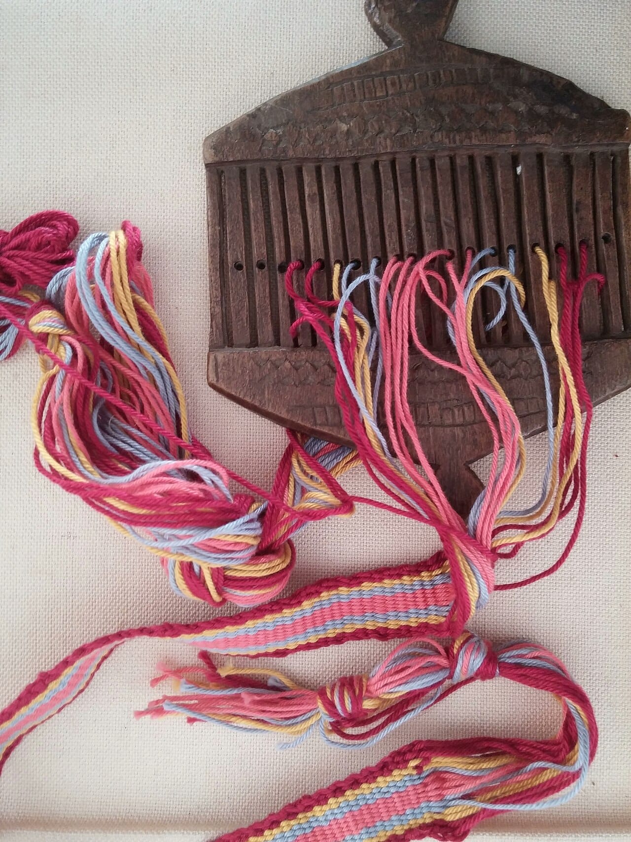Warp-faced tape woven on a rigid heddle loom, showing dense parallel warp threads covering the weft entirely