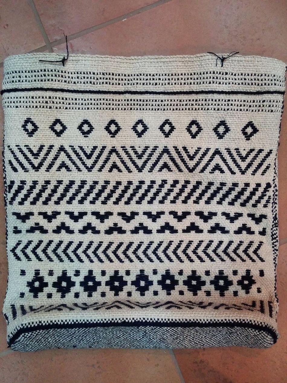 A hand-woven bag on a rigid heddle loom, cotton warp threads visible through the heddle mechanism