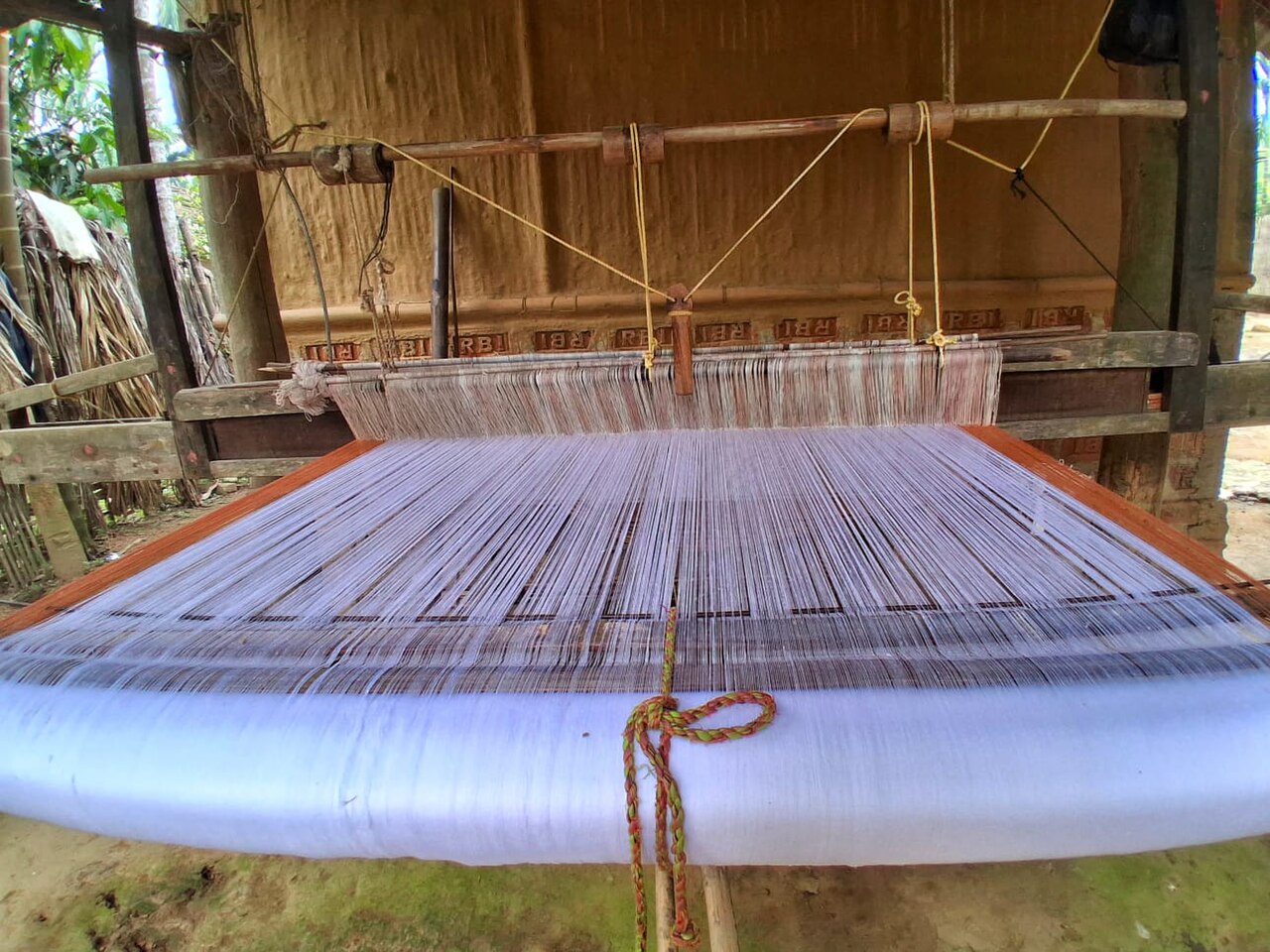 A traditional manual handloom with beater, heddle, warp beam, and cloth beam showing the complete structure of a floor loom