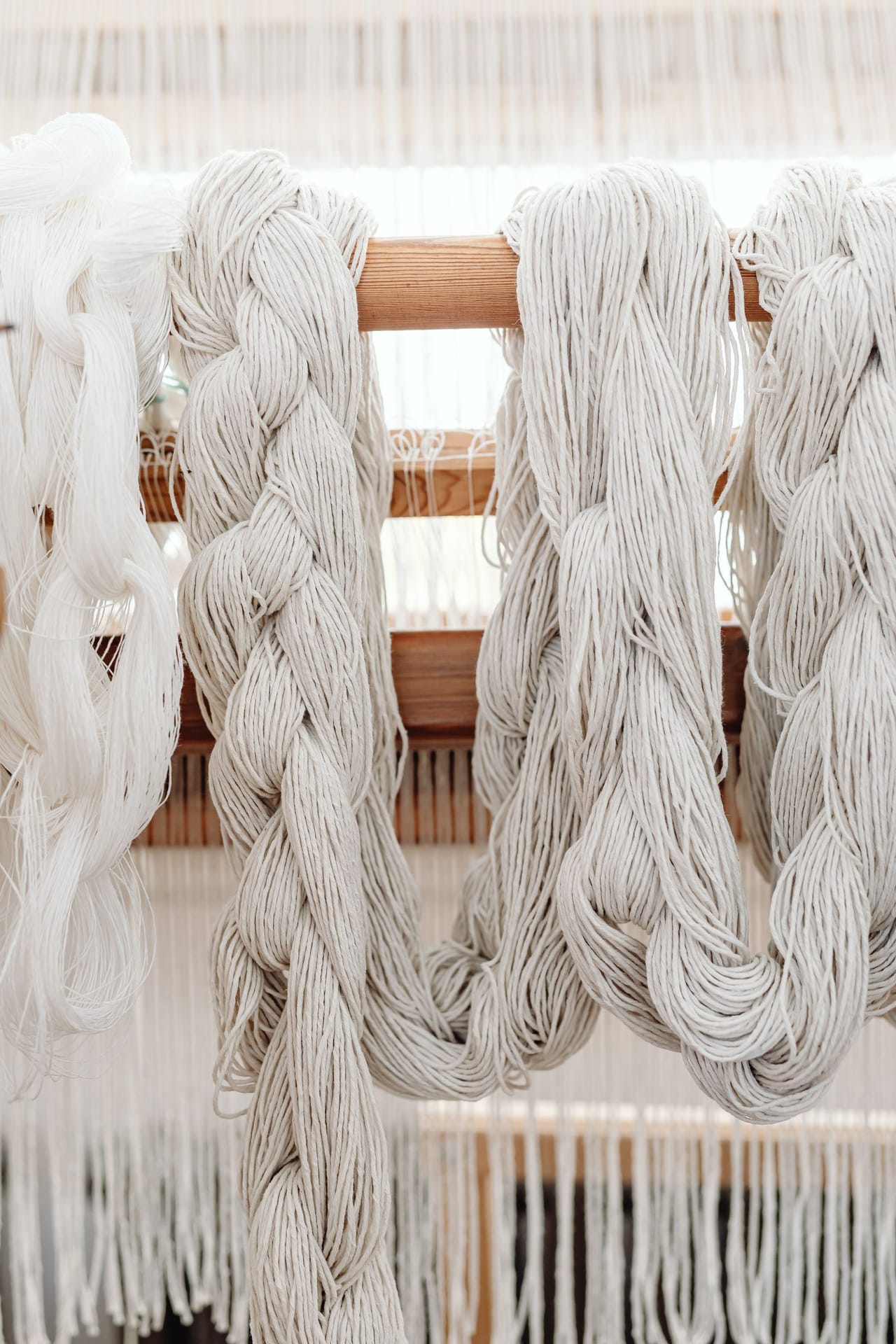 Floor loom with warp threads set up through the heddles, showing the loom in its warped state ready for weaving